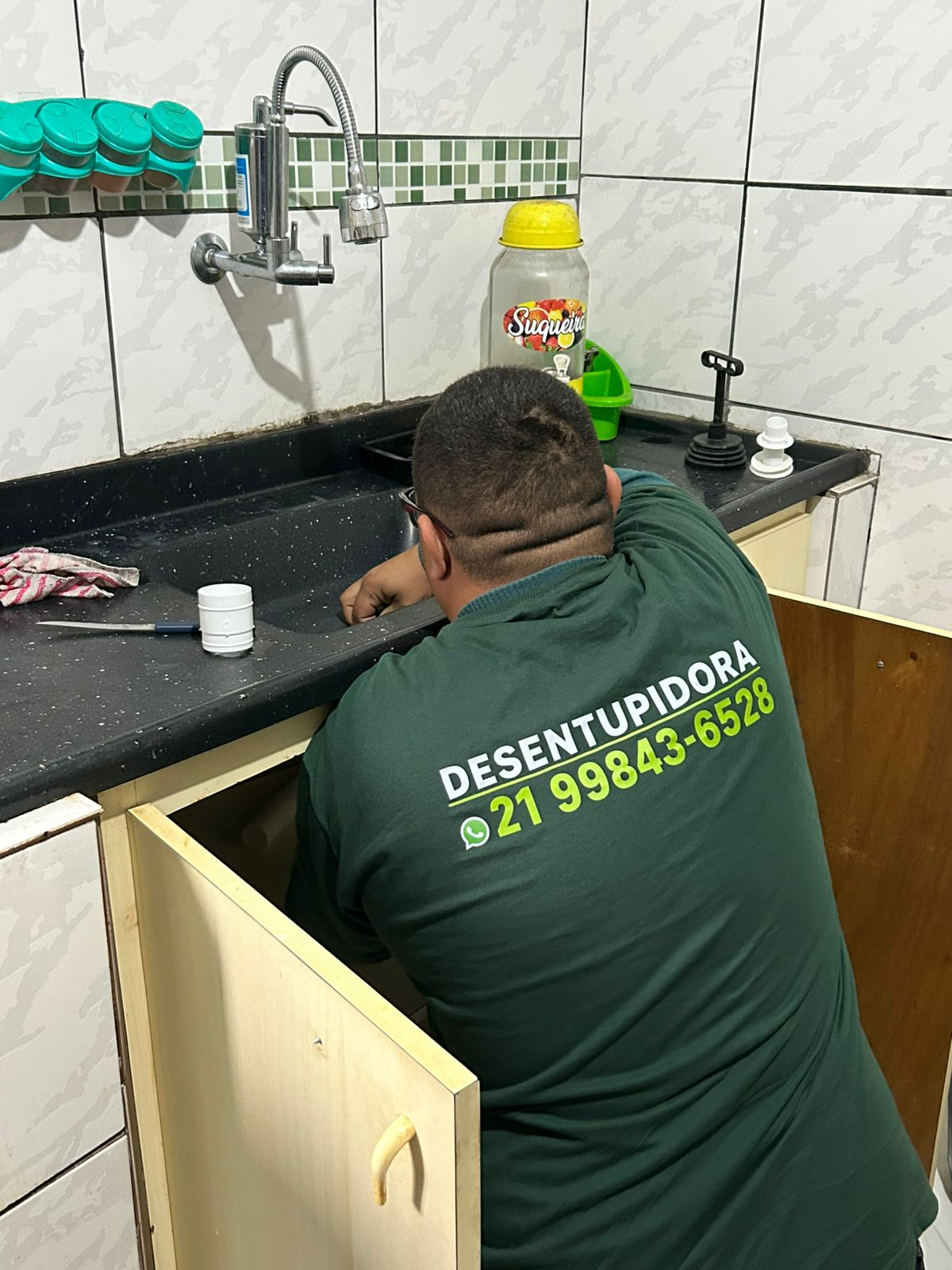 Técnico da ADL Desentupidora desentupindo pia de cozinha
