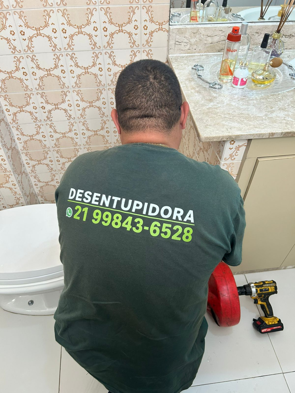 Técnico da ADL Desentupidora desentupindo vaso sanitário